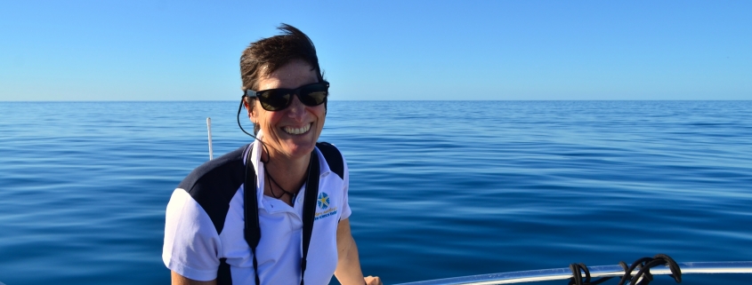 Dr Kelly Waples on a boat with ocean behind her.