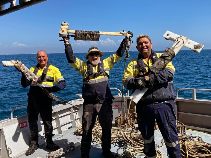 Three men from the Noise theme team hold up recorders they retrieved from Cockburn Sound.